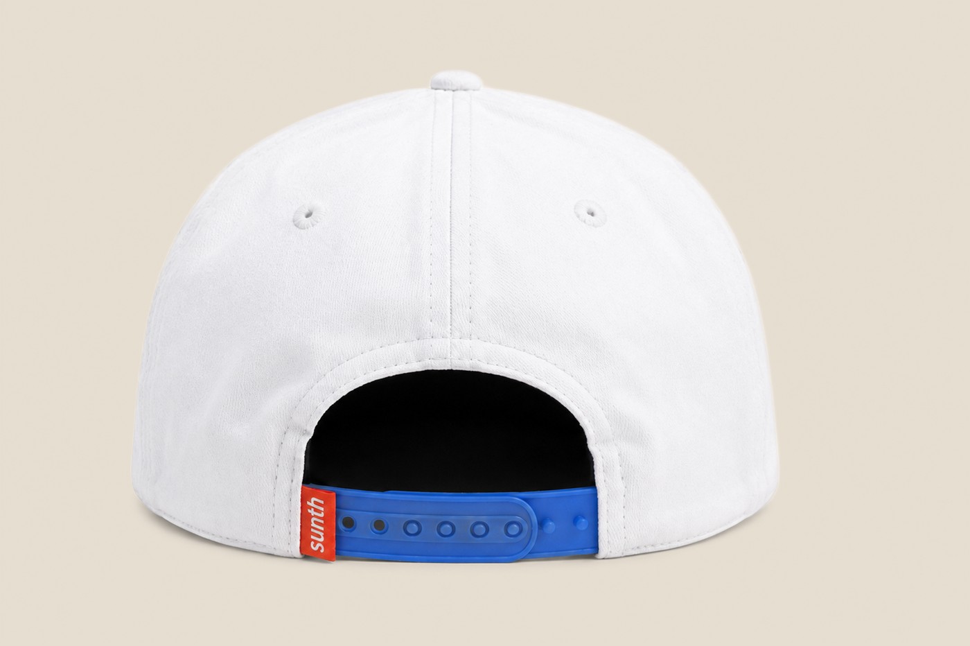 Back of a white cap showing the blue snapback closure and woven label