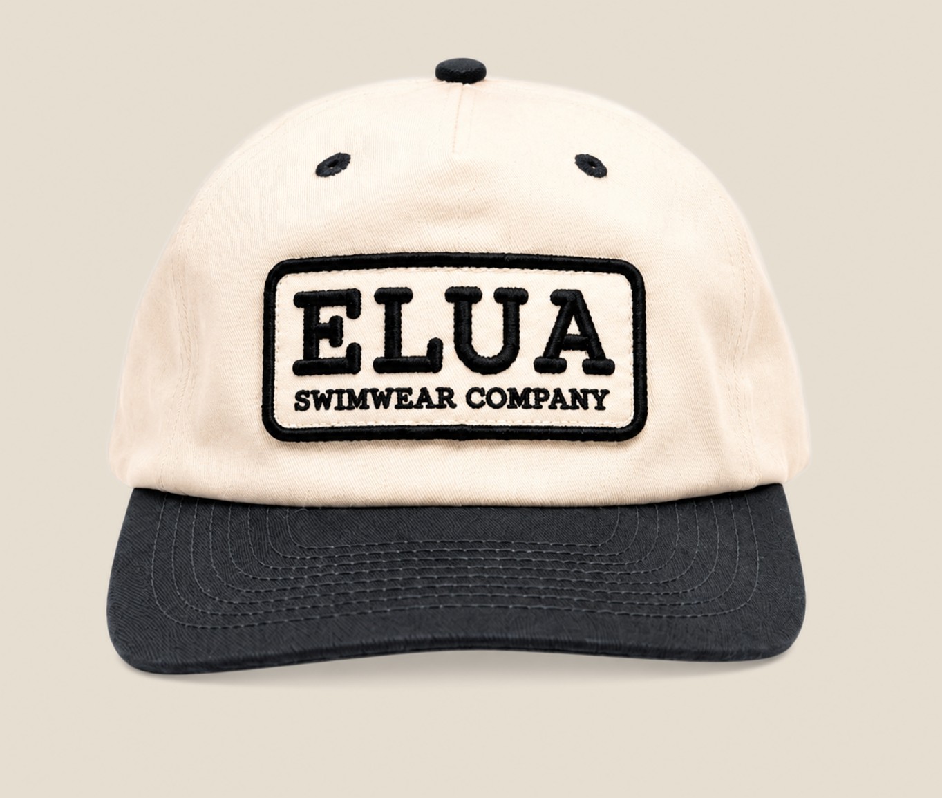 Cream and black Elua Swimwear patch cap, front view