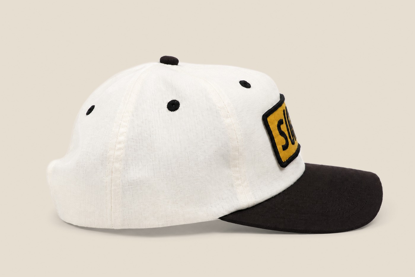 White and black Sunth cap with yellow patch, front view