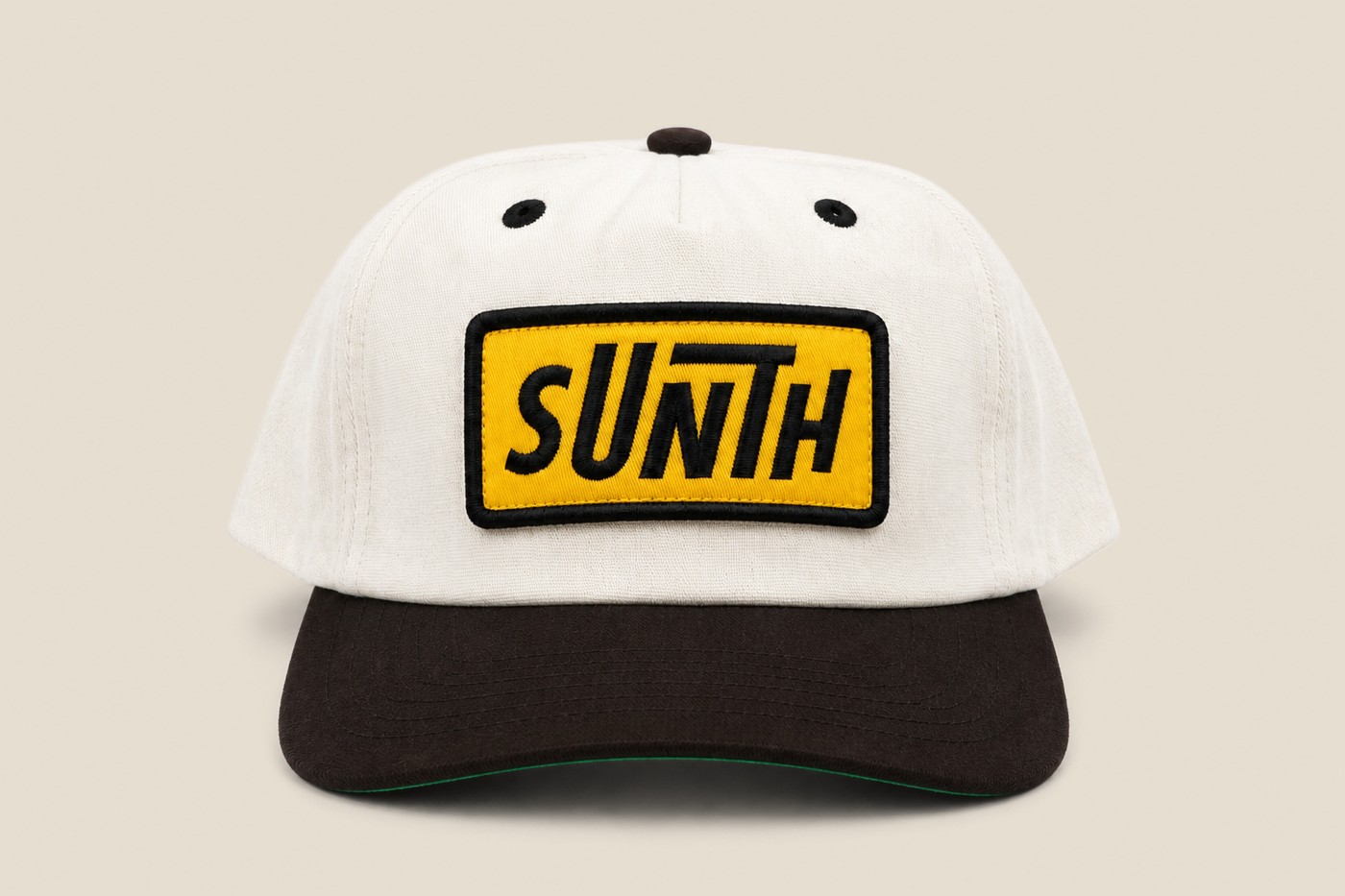 White and black Sunth cap with yellow patch, side profile