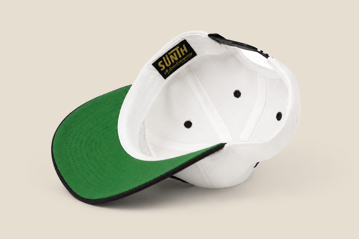 White and black Sunth cap, interior with green under brim