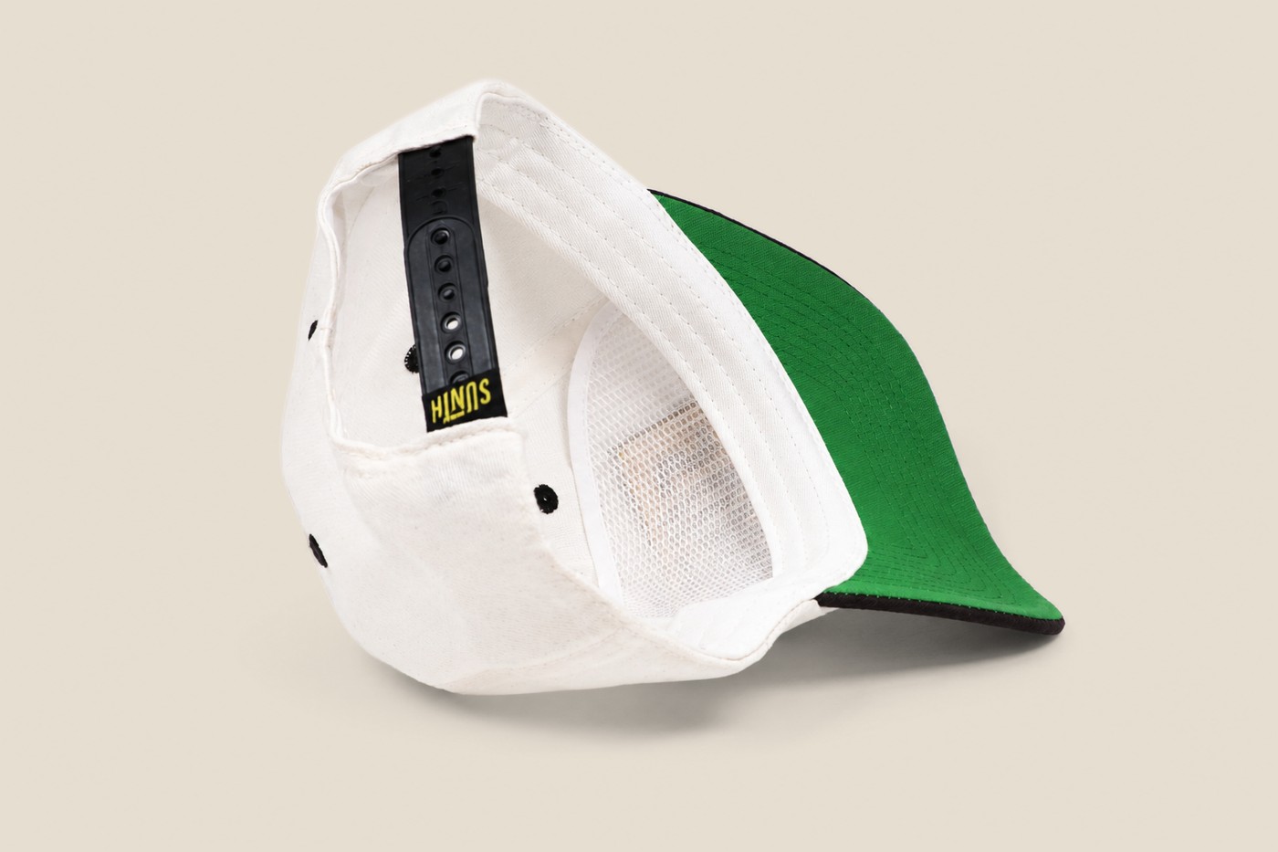 White cap flipped to show a green under brim